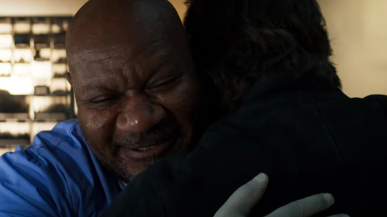 Luther (Ving Rhames) smiles as he hugs Ethan Hunt (Tom Cruise), whose back faces the camera
