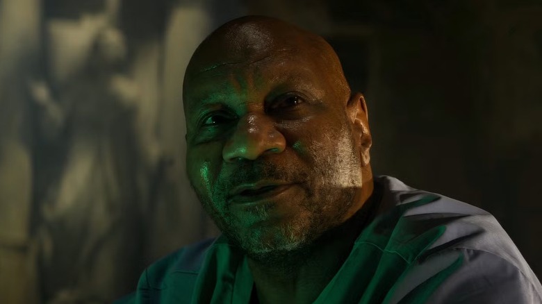 Luther (Ving Rhames) sits and looks up at someone off to his right
