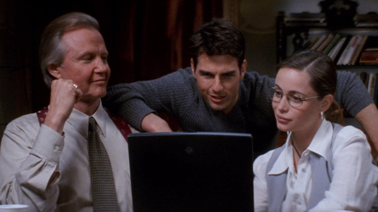 Jon Voight as Jim Phelps, Tom Cruise as Ethan Hunt, and Emmanuelle Béart as Claire looking at a computer in Mission: Impossible