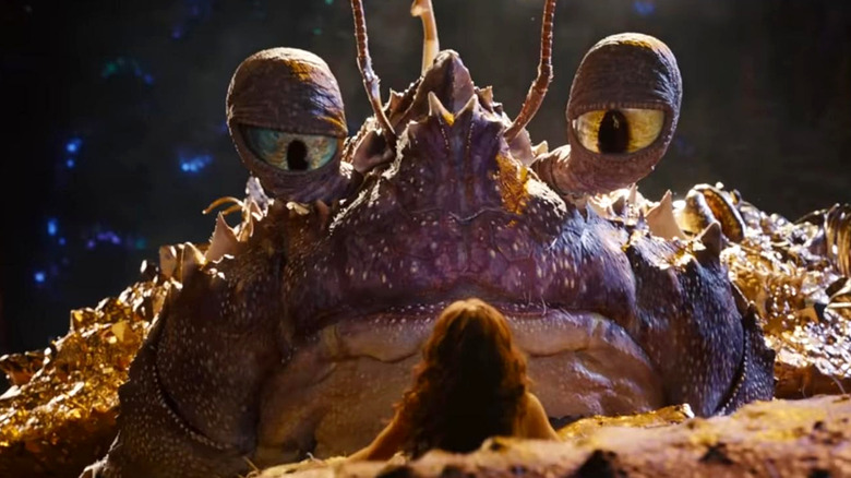 Tamatoa the crab holding Moana in its pincer in Moana