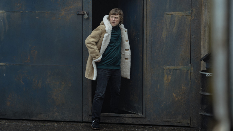 Johnny Flynn's Frankie Cooper steps out of a door in MobLand