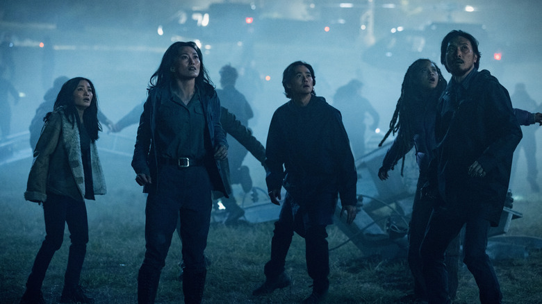 Anna Sawai as Cate, Mari Yamamoto as Keiko, Ren Watabe as Kentaro, Kiersey Clemons as May, and Takehiro Hira as Hiroshi standing amid wreckage and looking up at a monster in Monarch: Legacy of Monsters