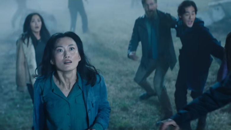 Mari Yamamoto as Keiko Miura, Anna Sawai as Cate Randa, Joe Tippett as Tim, and Ren Watabe as Kentaro Randa staring up at a monster in Monarch: Legacy of Monsters