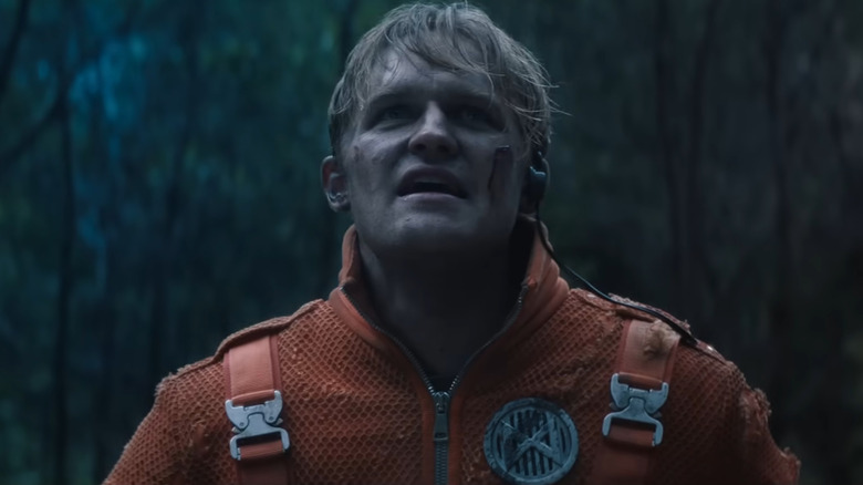 Wyatt Russell as Lee Shaw wearing an orange jumpsuit and a bloody cheek in Monarch: Legacy of Monsters