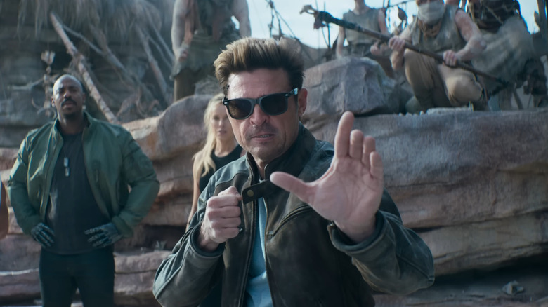Karl Urban as Johnny Cage getting ready to fight with Jax and Sonya in the background in Mortal Kombat II