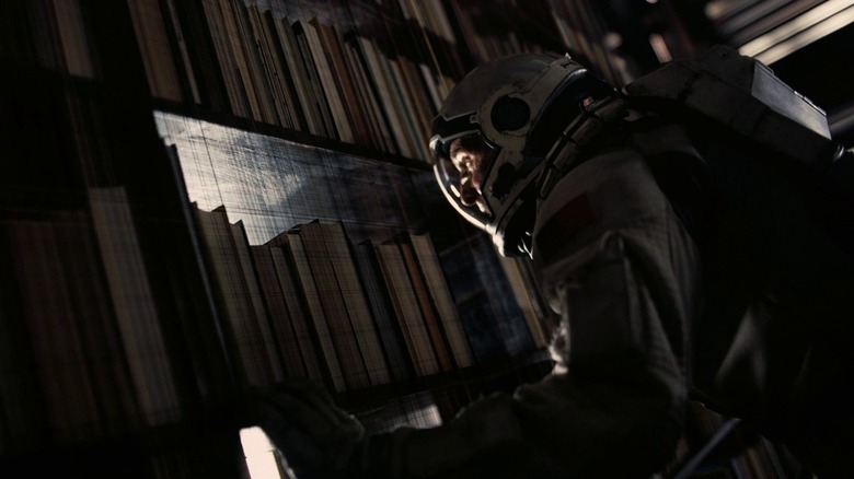 Coop (Matthew McConaughey) looking through the bookcase in Interstellar