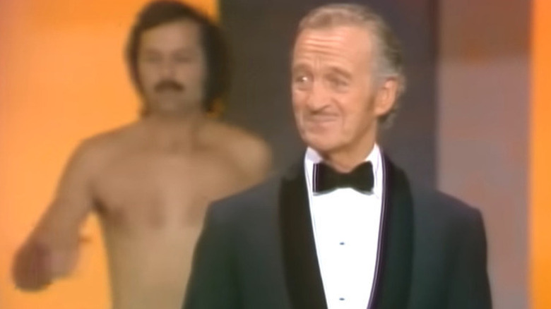 Man behind David Niven on Oscars stage