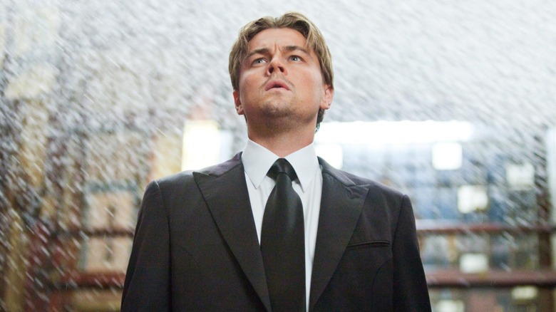man looking up in a suit surrounding by rain inside