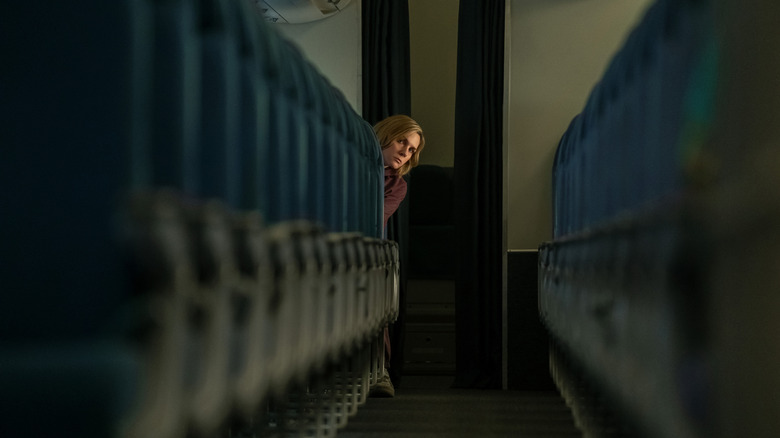 Carol Sturka peeking from the back seat of an empty plane on Pluribus