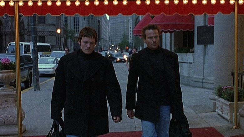 The Boondock Saints pointing guns at a man's head in a courtroom