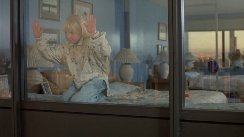 Carol Anne (Heather O'Rourke) with hands against window in Poltergeist III