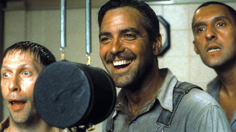 Tim Blake Nelson as Delmar, George Clooney as Ulysses, and John Turturro as Pete dweeb it up in front of a speaker in O Brother Where Art Thou