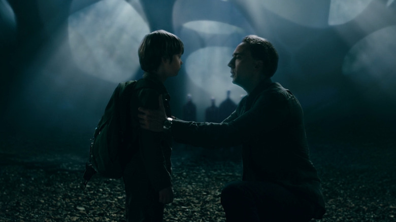 Nicolas Cage kneels with son