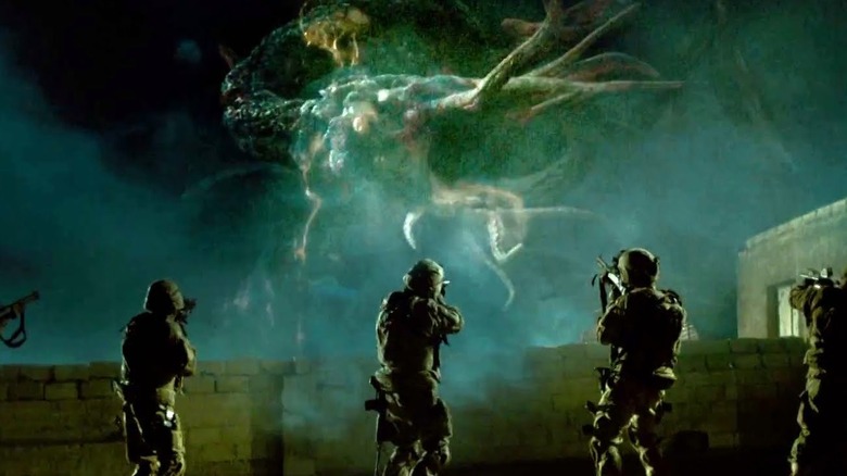 Military men approach alien creature