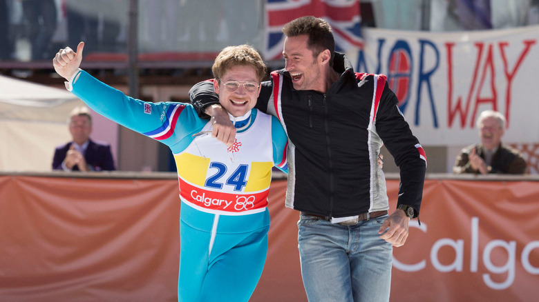 Taron Egerton walks with Hugh Jackman