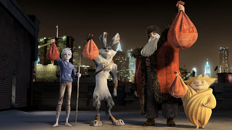 Jack Frost, Bunny, North and the Sandman holding up bags