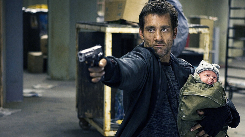 Clive Owen Holds Baby Points Gun