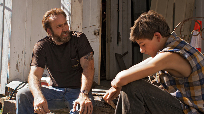 Nicolas Cage sits with Tye Sheridan