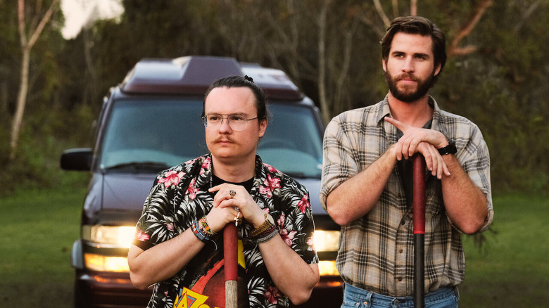 Clark Duke and Liam Hemsworth with shovels