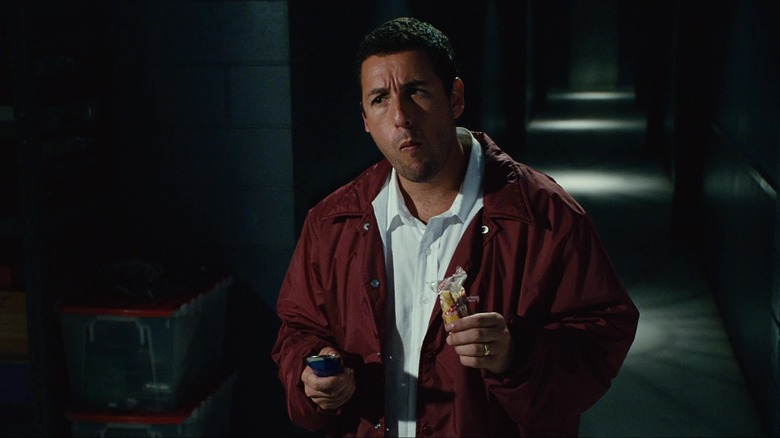 Adam Sandler as Michael Newman in Click, eating a Twinkie and looking off at someone.