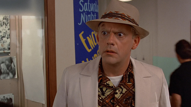 Christopher Lloyd as Doc Brown looking baffled in a hat and suit in Back to the Future