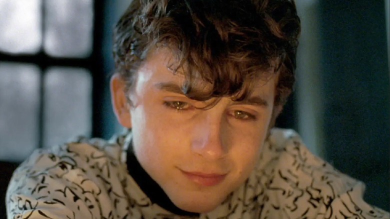 Elio, heartbroken, stares into the fire