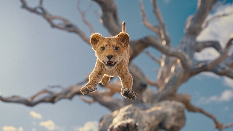 Baby Mufasa jumps from a tree in Mufasa: The Lion King