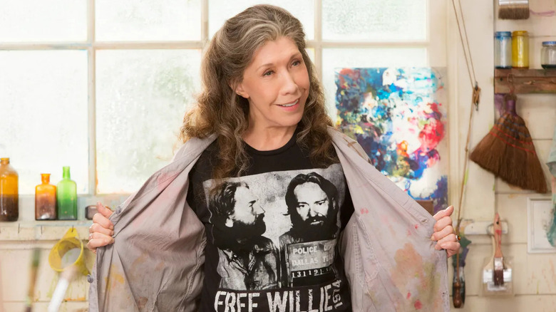 Lily Tomlin as Frankie, holding open a shirt in an art studio on Grace and Frankie