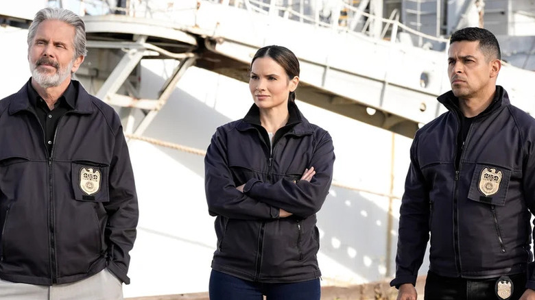Gary Cole's Alden Parker, Katrina Law's Jessica Knight, and Wilmer Valderrama's Nick Torres standing by a white ship on NCIS