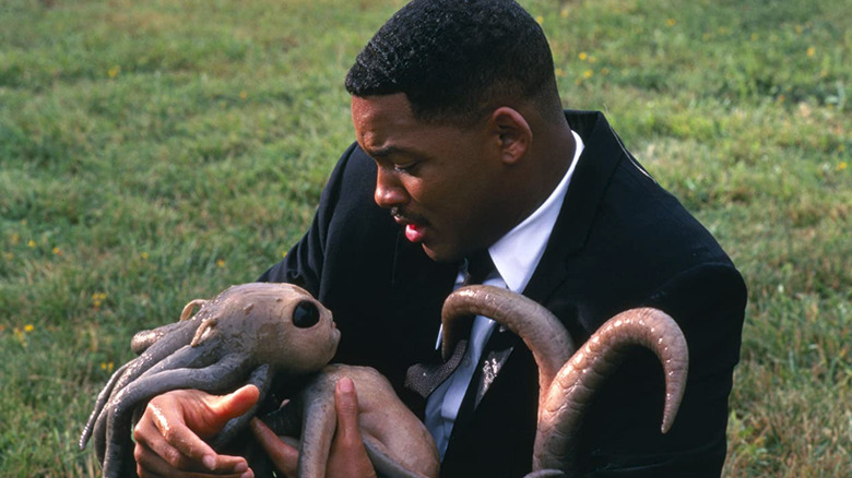 Smith's Men in Black character holding baby alien
