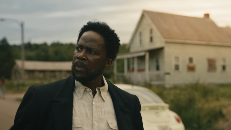 Harold Perrineau's Boyd Stevens looks off to his right as he walks past a house in From