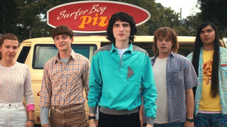 Mike, Will, Argyle, Jonathan, and Eleven standing in front of a pizza van in Stranger Things season 4