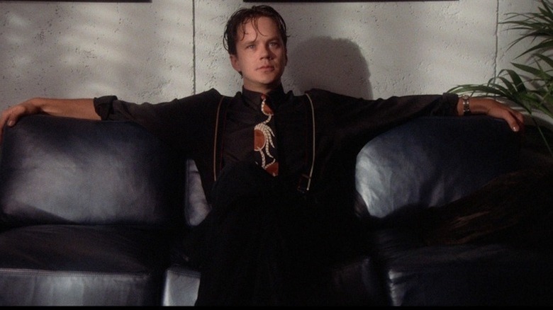 Tim Robbins stares blankly from a black couch in The Player