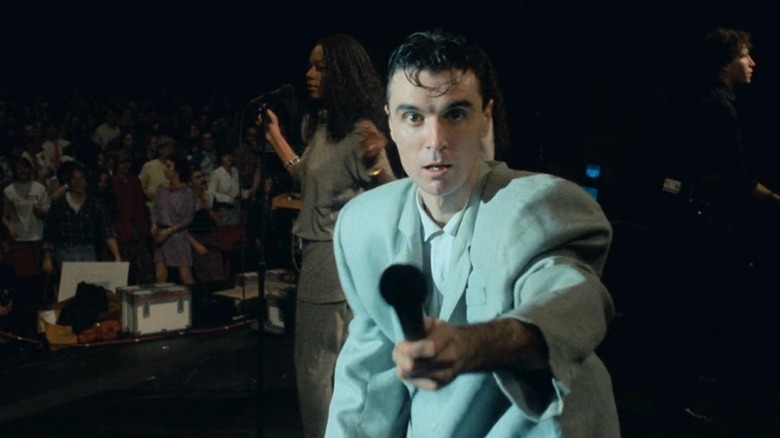 Stop Making Sense - David Byrne looking at camera and holding out microphone
