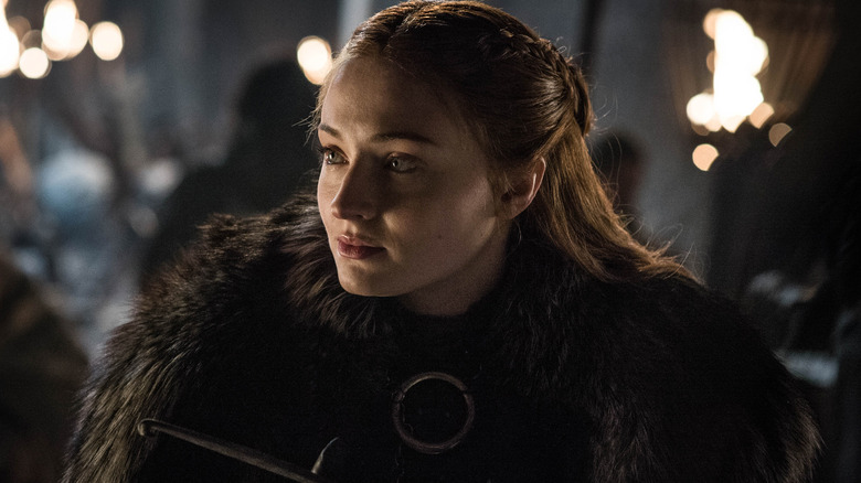 Sansa lit by torches in a fur coat in Game of Thrones