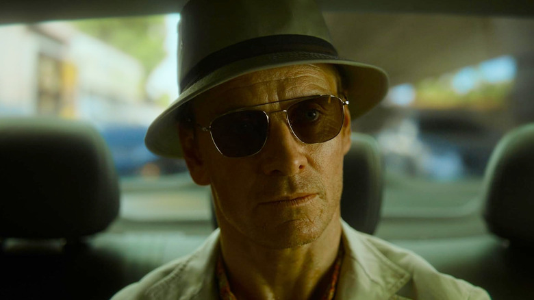 Michael Fassbender as a nameless assassin wearing sunglasses in The Killer