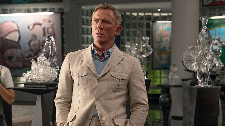 Daniel Craig as Benoit Blanc standing with a look of surprise on his face in Glass Onion: A Knives Out Mystery