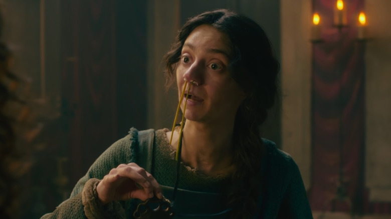 Licisca (Tanya Reynolds) with flowers up her nose and an amulet to ward off plague in The Decameron