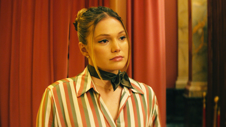 Olivia Holt's Sophie Arbus stands against a curtain in Jingle Bell Heist
