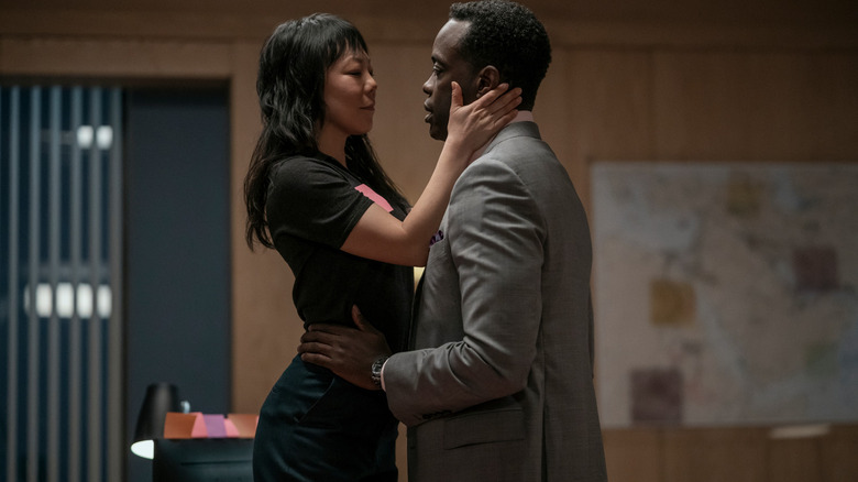 Ali Ahn as Eidra Park embracing Ato Essandoh as Stuart Hayford in an office in The Diplomat