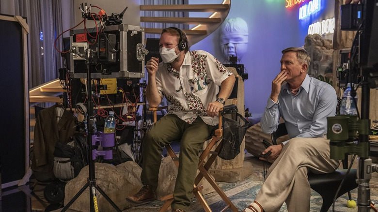 Rian Johnson sits with Daniel Craig on the set of Glass Onion: A Knives Out Mystery