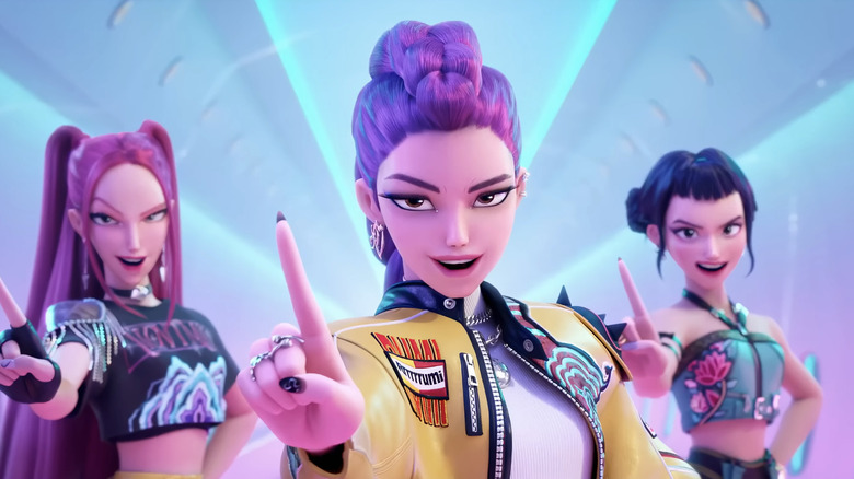 Arden Cho's Rumi stands flanked by May Hong's Mira, and Ji-young Yoo's Zoey as they pose in KPop Demon Hunters