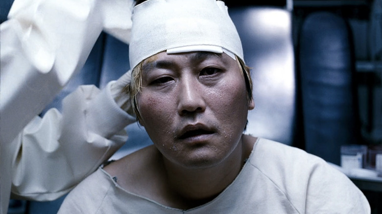 Song Kang-ho's Park Gang-du has his head bandanged removed by an unseen doctor in The Host