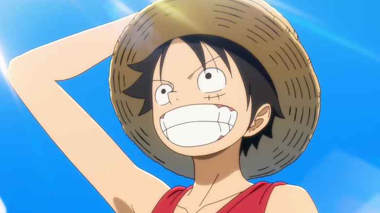 Luffy grinning in the sunlight while wearing a hat in The One Piece