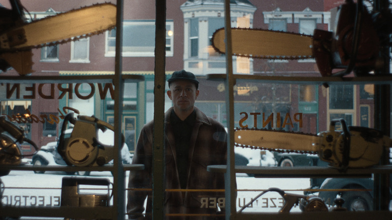 Ed Gein standing outside of a window in "Monster: The Ed Gein Story"