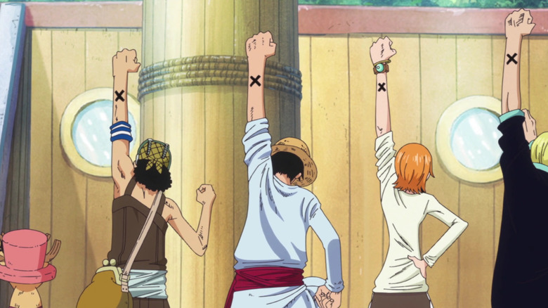 The Straw Hats raising their arms together in a sign of friendship in One Piece