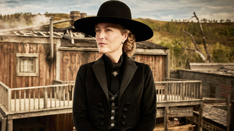 Gillian Anderson as Constance Van Ness standing in front of an Old West town in The Abandons