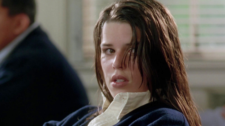 Neve Campbell as Bonnie Harper sitting in a classroom looking shocked in The Craft