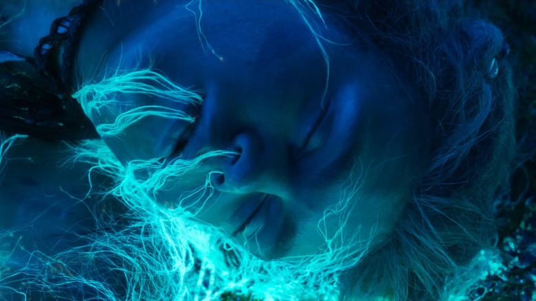 Sam Champion as Spider laying unconscious with tree roots covering his face in Avatar: Fire and Ash