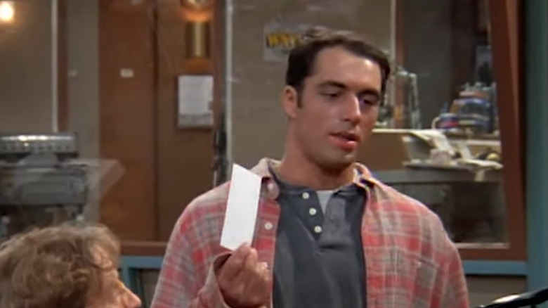 Joe (Joe Rogan) holding paper in Newsradio